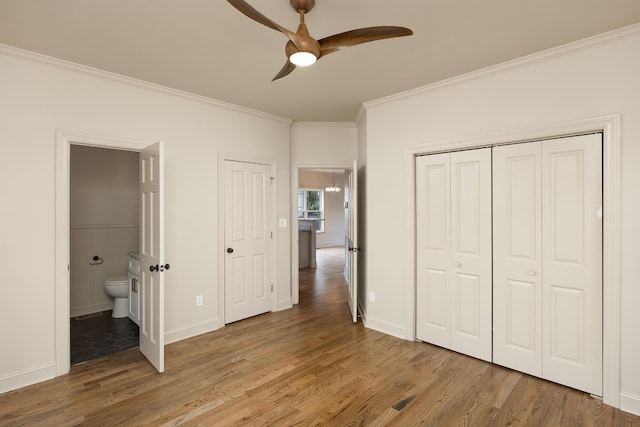 unfurnished bedroom featuring ornamental molding, hardwood / wood-style flooring, ensuite bathroom, and ceiling fan