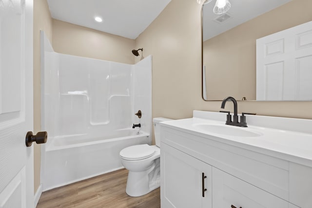 full bathroom featuring toilet, hardwood / wood-style flooring, vanity, and  shower combination