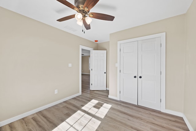 unfurnished bedroom featuring a closet, light wood-type flooring, and ceiling fan