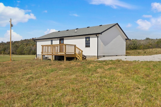 back of house with a wooden deck and a lawn