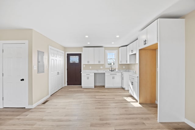 kitchen with sink, white cabinetry, and light wood-type flooring