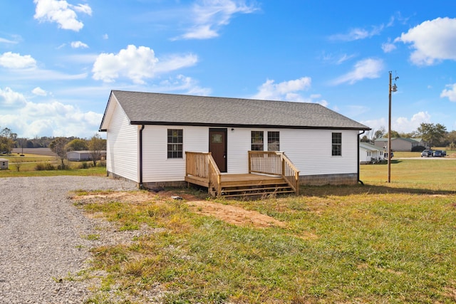 view of front facade with a wooden deck and a front lawn