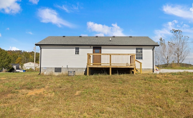 back of property featuring a wooden deck and a yard