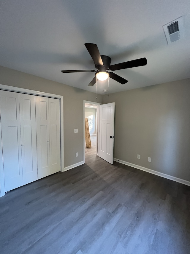 unfurnished bedroom with a closet, ceiling fan, and dark hardwood / wood-style flooring