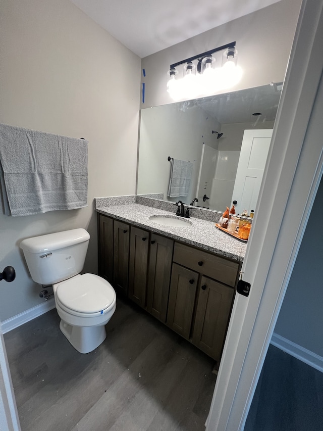 bathroom featuring vanity, hardwood / wood-style floors, and toilet