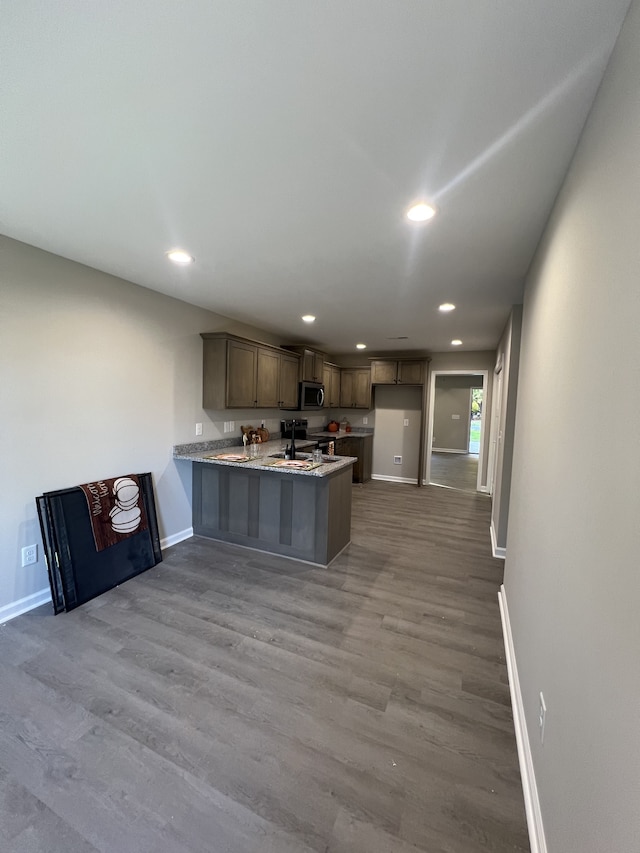 kitchen with light hardwood / wood-style floors, sink, and kitchen peninsula