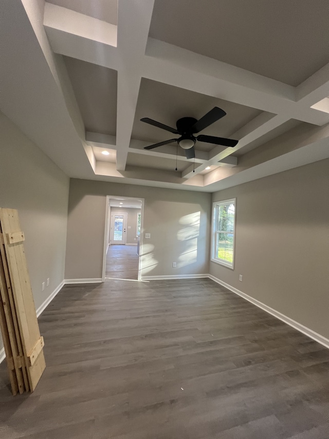 spare room with coffered ceiling, dark hardwood / wood-style floors, beam ceiling, a tray ceiling, and ceiling fan