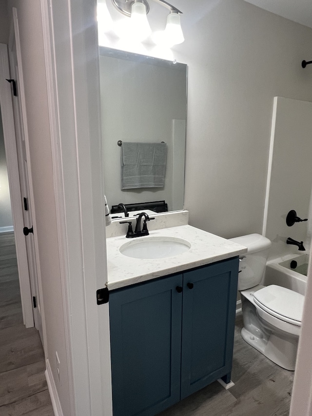 full bathroom with vanity, toilet, bathtub / shower combination, and hardwood / wood-style floors