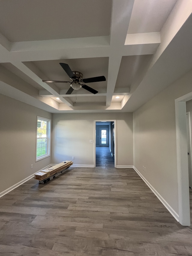 empty room with beamed ceiling, coffered ceiling, wood-type flooring, and ceiling fan