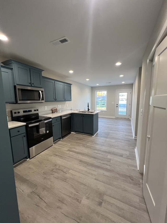 kitchen featuring sink, light hardwood / wood-style flooring, kitchen peninsula, and stainless steel appliances