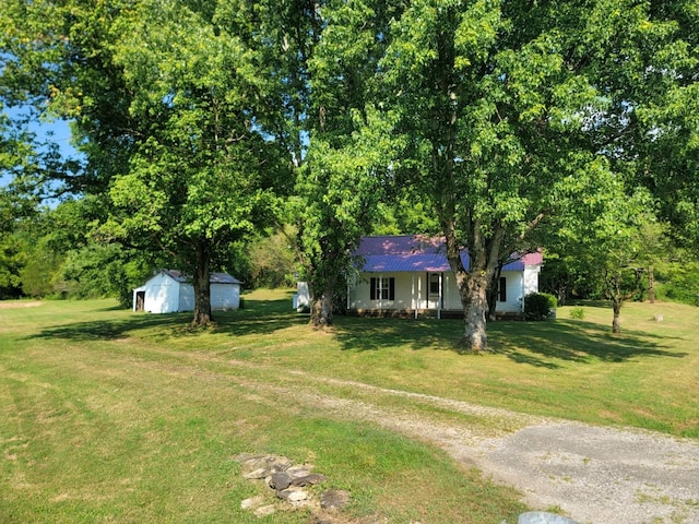 ranch-style house featuring a front yard and an outbuilding