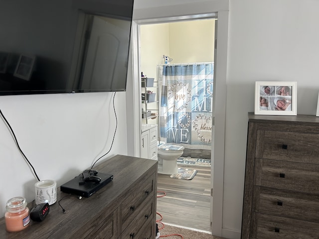 interior space with hardwood / wood-style flooring and ensuite bath