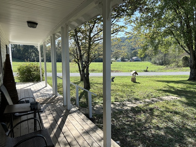 wooden deck featuring a yard and covered porch