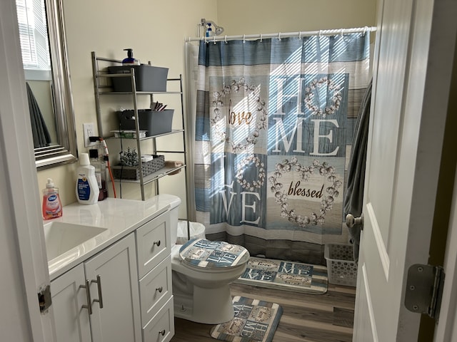 bathroom featuring vanity, toilet, curtained shower, and hardwood / wood-style floors