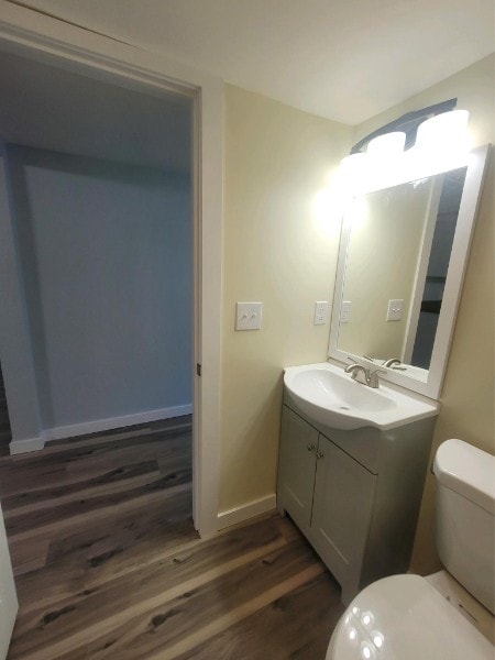 bathroom with vanity, toilet, and hardwood / wood-style floors