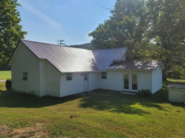 rear view of house featuring a yard and french doors