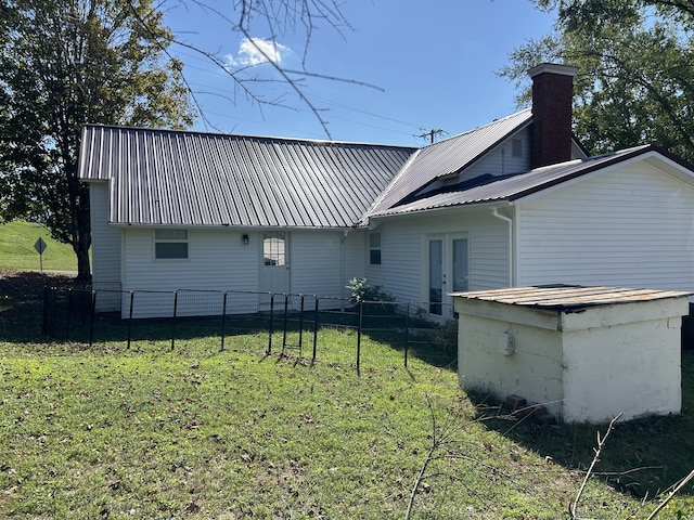 rear view of property featuring a lawn