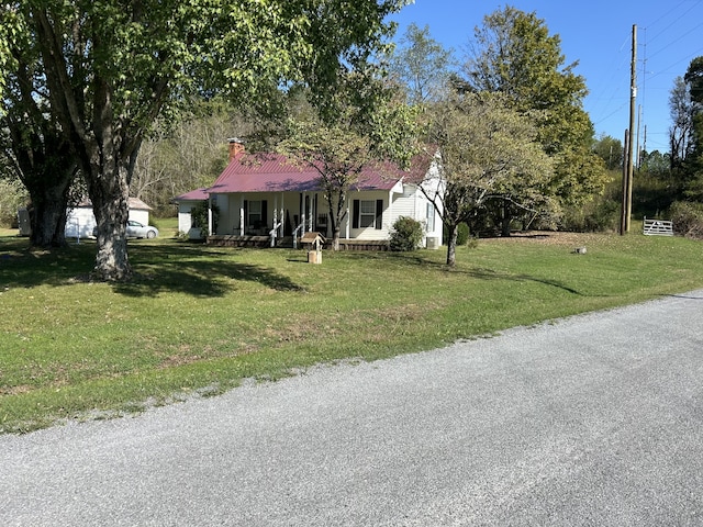 view of front of home with a porch, a front yard, and a garage