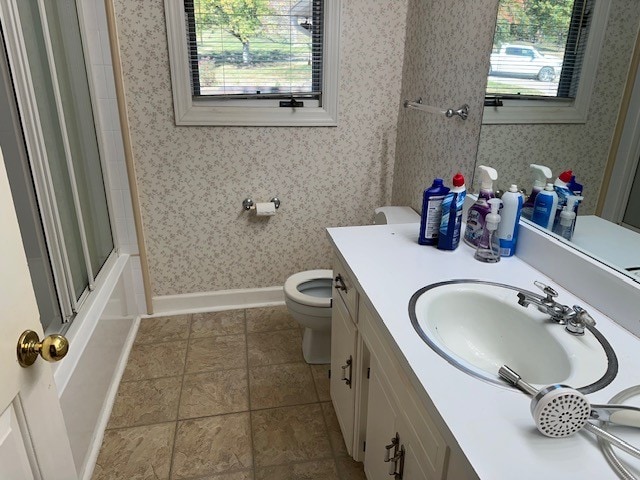 full bathroom featuring toilet, enclosed tub / shower combo, a healthy amount of sunlight, and vanity