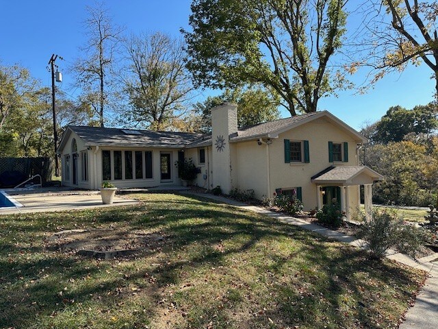 rear view of property featuring a patio and a lawn