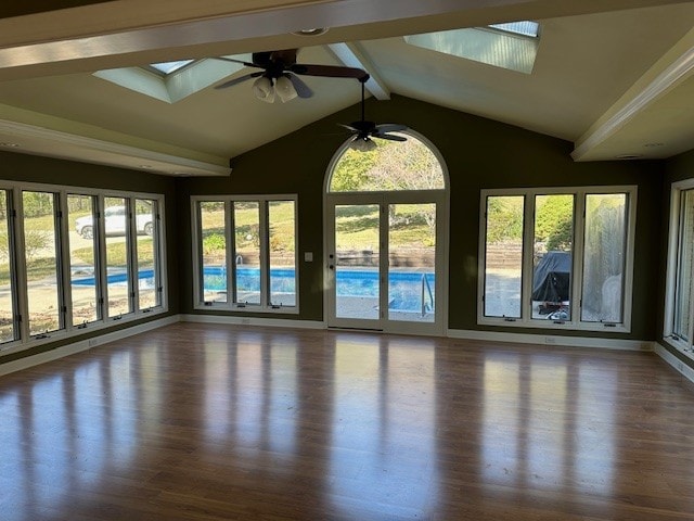 unfurnished sunroom featuring vaulted ceiling with skylight and ceiling fan