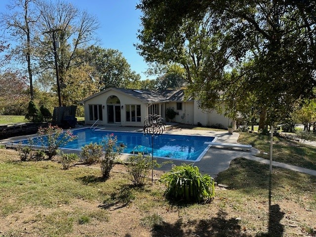 view of pool with a diving board and a patio area