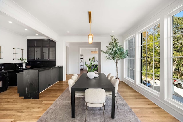 dining area featuring light hardwood / wood-style flooring and ornamental molding