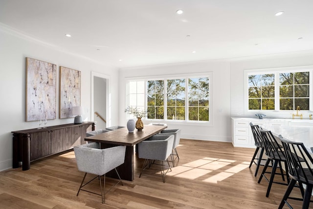 dining room featuring light hardwood / wood-style floors and crown molding