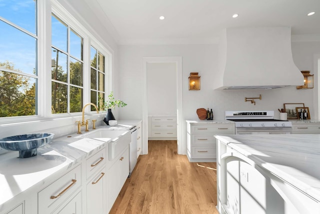 kitchen featuring custom exhaust hood, white electric stove, ornamental molding, light hardwood / wood-style floors, and white cabinetry