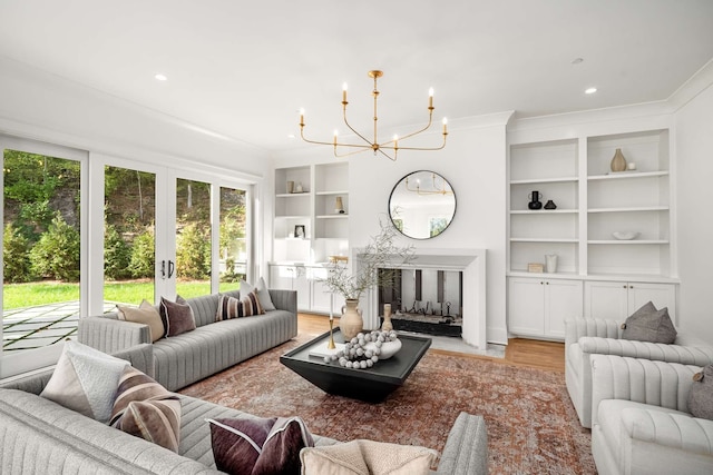 living room featuring a chandelier, crown molding, and light hardwood / wood-style floors