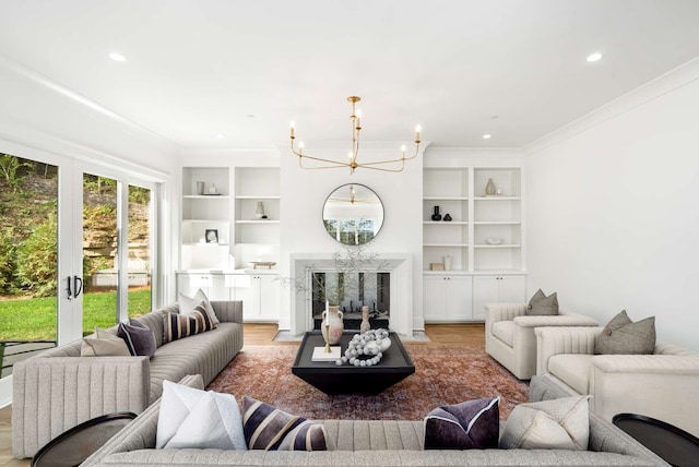 living room with french doors, light hardwood / wood-style floors, an inviting chandelier, and ornamental molding