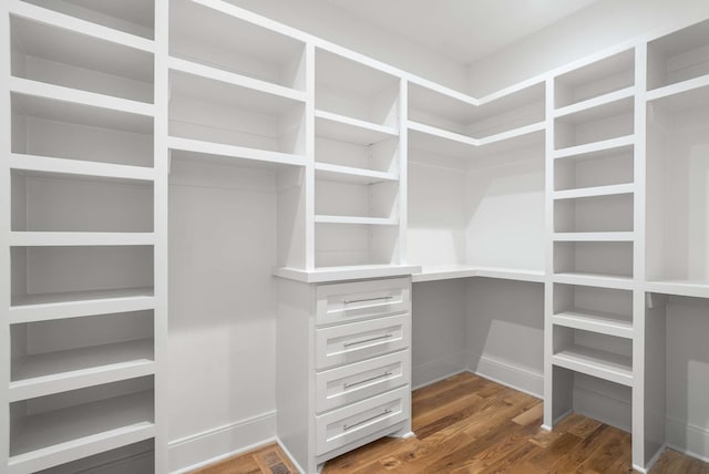 walk in closet with dark wood-type flooring