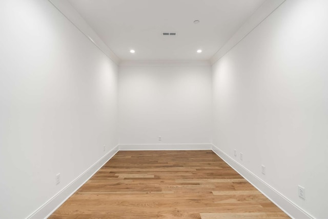 empty room featuring light hardwood / wood-style floors and crown molding