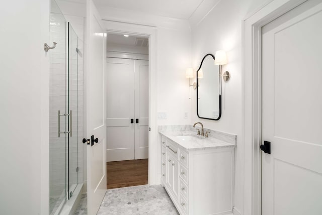 bathroom featuring vanity, crown molding, wood-type flooring, and walk in shower