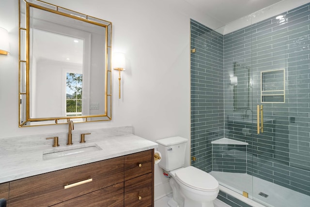 bathroom featuring an enclosed shower, vanity, and toilet