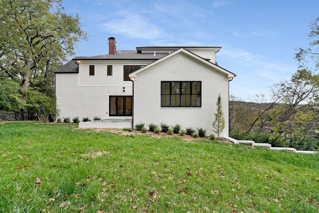 rear view of property with a yard and a patio area