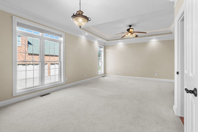 carpeted empty room featuring crown molding, a tray ceiling, and ceiling fan