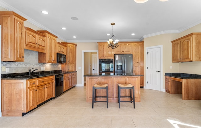 kitchen with black appliances, a center island, an inviting chandelier, and ornamental molding