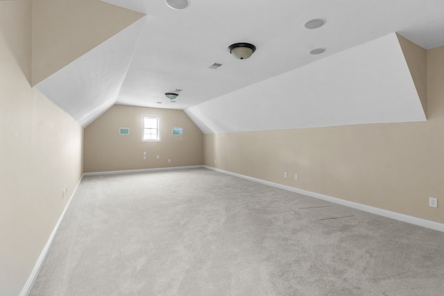 bonus room featuring lofted ceiling and light colored carpet