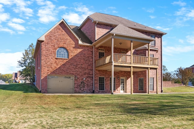 rear view of house featuring a balcony, a garage, and a lawn