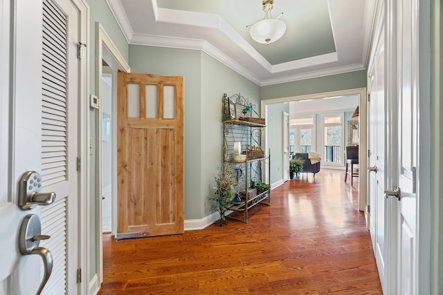 entryway featuring crown molding, hardwood / wood-style flooring, and a tray ceiling