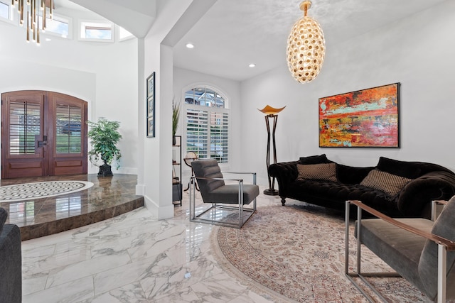 living room with french doors, a notable chandelier, and plenty of natural light