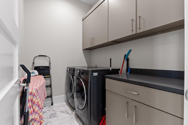 clothes washing area featuring washer and dryer and cabinets