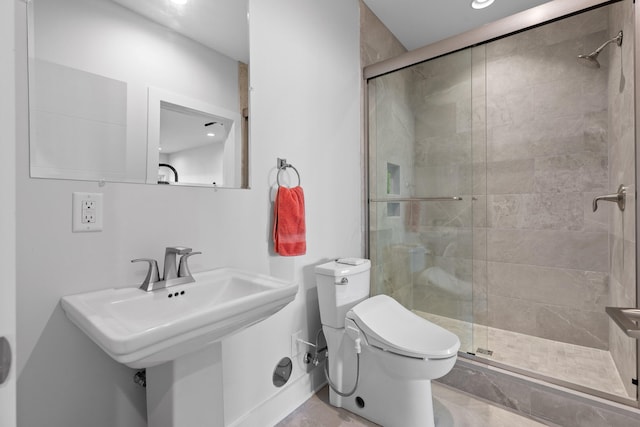 bathroom featuring sink, toilet, and a shower with shower door