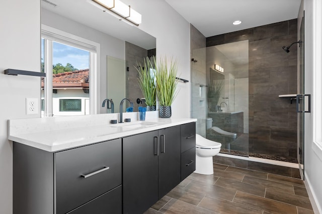 bathroom with vanity, an enclosed shower, and toilet