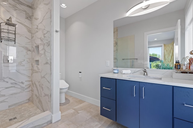 bathroom with vanity, toilet, and a tile shower