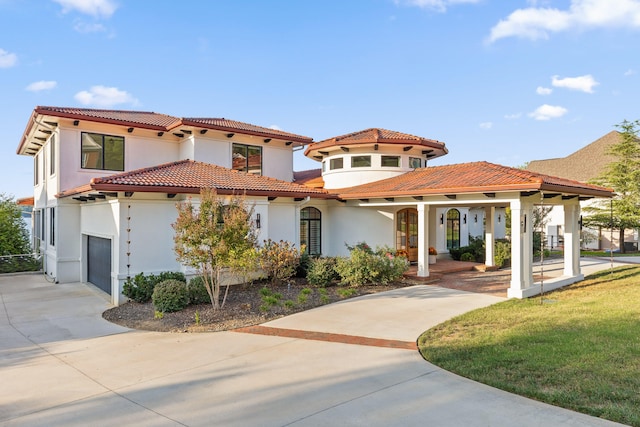 mediterranean / spanish-style house featuring a front lawn and a garage