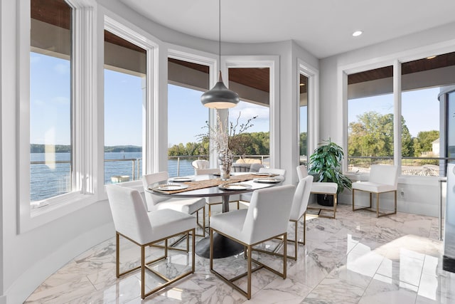 sunroom featuring a water view