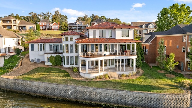 rear view of house with a water view, a lawn, a balcony, and central air condition unit