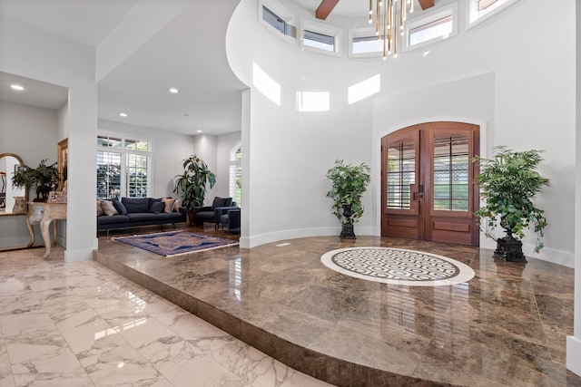 entryway featuring french doors and a towering ceiling